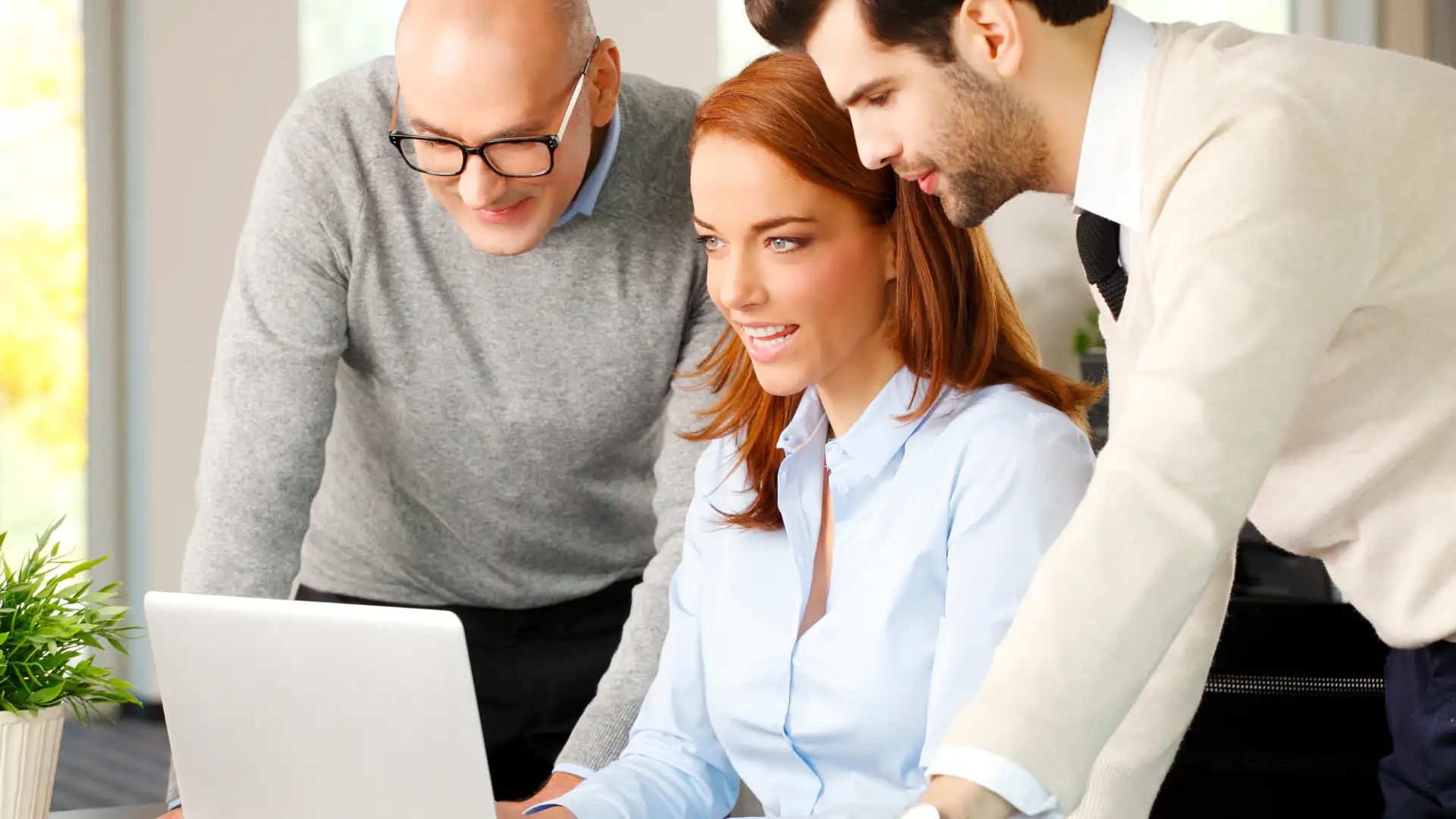 Small business owner planning work at a desk with a laptop